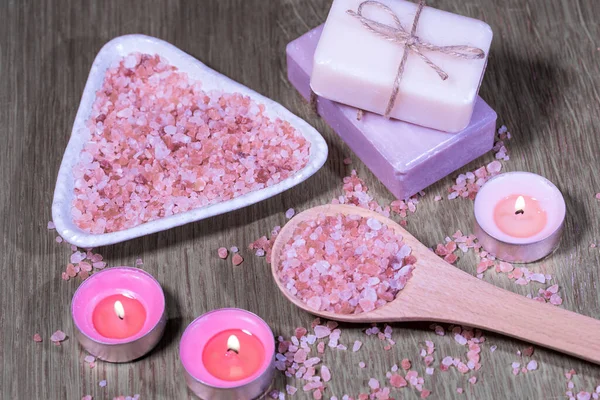 Composition spa, beauty and wellness treatment, background with Himalayan salt, natural soap and candles on a wooden background. High quality photo