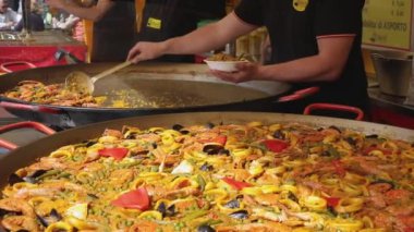 Pilavlı İspanyol deniz ürünleri paella, bezelye, karides, midye, kalamar, karides. Ateşte pişiyor. Sokak yemeği. Ağır çekim. Seçici odaklanma. Yüksek kaliteli FullHD görüntüler
