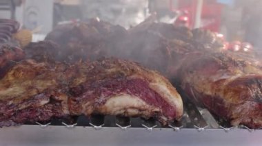 Izgara biftek ve domuz pirzolası pişiriyorum. Sokak yemekleri konsepti. Ağır çekim. Yüksek kaliteli FullHD görüntüler