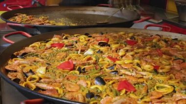 Pilavlı İspanyol deniz ürünleri paella, bezelye, karides, midye, kalamar, karides. Ateşte pişiyor. Sokak yemeği. Ağır çekim. Seçici odaklanma. Yüksek kaliteli FullHD görüntüler