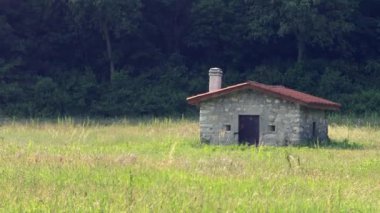 Arazinin ortasında bir kulübe. Yağmurdan ve güneşten korunmak ve iş aletlerini depolamak için 26.05.2023, Brescia, İtalya. Yazı işleri. Yüksek kalite 4k görüntü