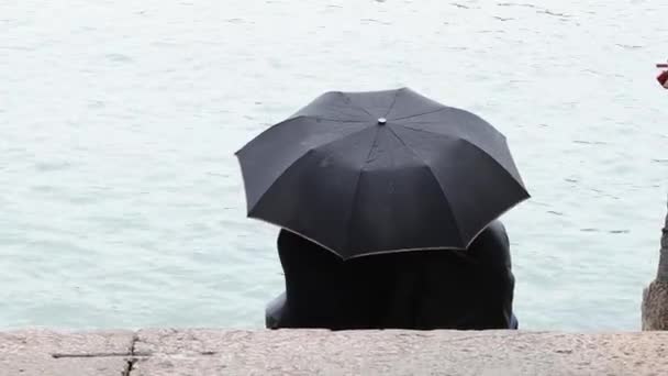 Couple Young People Sit Black Umbrella Shore Lake Rainy Day — Stock Video