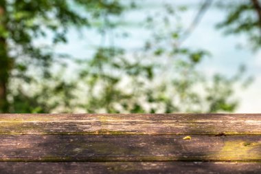  Bulanık doğa arka planının, güneş ışığının, ilkbaharın, kopyalama alanının üzerindeki boş ahşap masa. Yüksek kalite fotoğraf