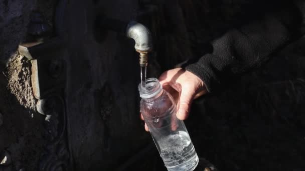Uomo Riempie Bottiglie Plastica Con Acqua Proveniente Una Fonte Acqua — Video Stock