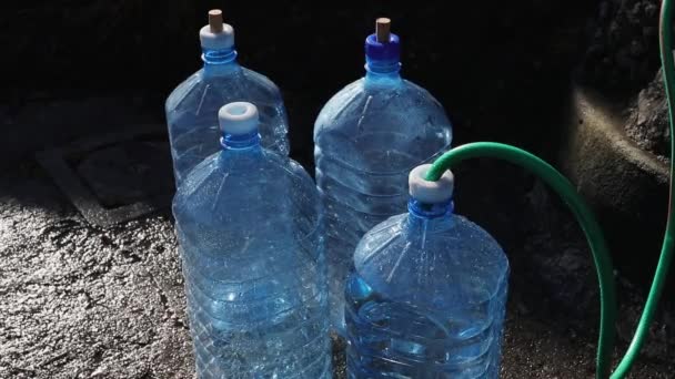 Мужчина Наполняет Пластиковые Бутылки Водой Природного Источника Воды Горах Концепция — стоковое видео