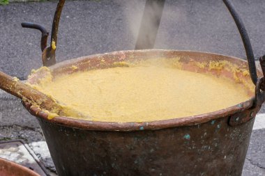 Büyük bir fıçı mısır lapası yangının üstünde kaynıyor. Yüksek kalite fotoğraf