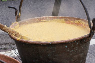 Büyük bir fıçı mısır lapası yangının üstünde kaynıyor. Yüksek kalite fotoğraf