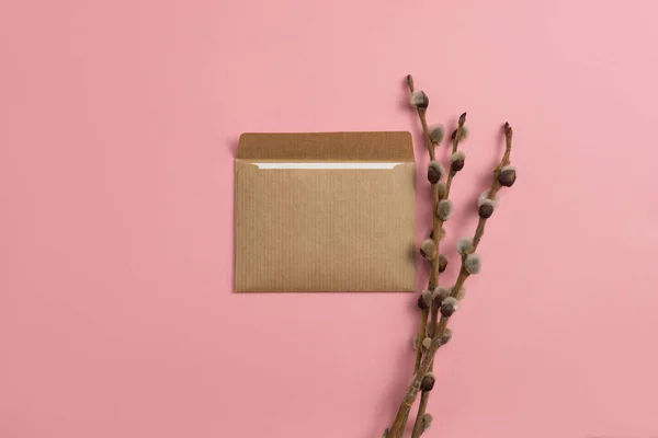 Mockup of an open card made of craft paper with a composition of flowering branches on a pink background