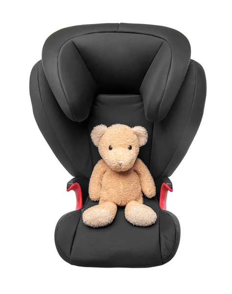 Soft toy bear in a child car seat. Isolated on white background.