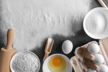 Products for baking on a black board. Background from flour.