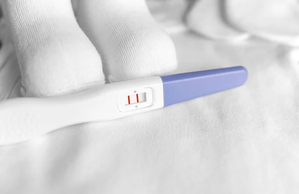 Hamilelik Testi Çocuk Kıyafetlerinin Arka Planında Sakin Bir Hayat — Stok fotoğraf