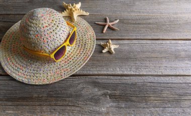 Şapkanın üzerinde güneş gözlüğü var. Ahşap arka plan. Metin için boşluk var.