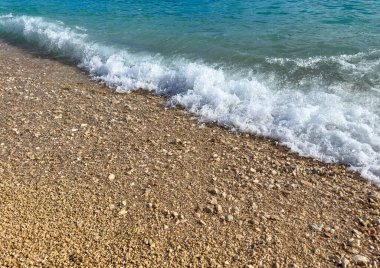 Sahilde küçük dalgalar kopuyor.