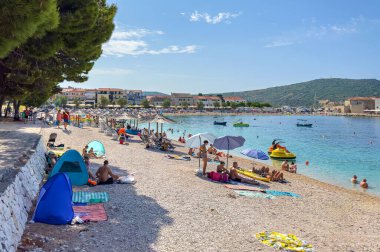 PRIMOSTEN, CROATIA - 27 Temmuz 2023: Hırvatistan 'ın Primosten kentindeki plajda insanlar.