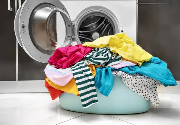 洗衣机洗的多种颜色的衣服放在篮子里 免版税图库照片
