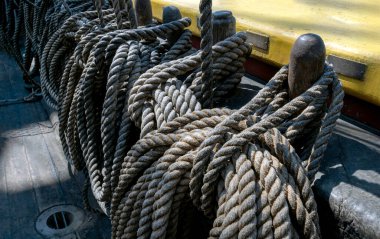 Yan yelkenlide bir sürü yıpranmış ip var. Halatları kıvrılmış eski bir tekne..