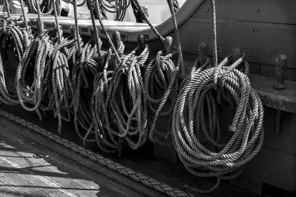 Black and white photography a lot of old ropes on the side sailboat.
