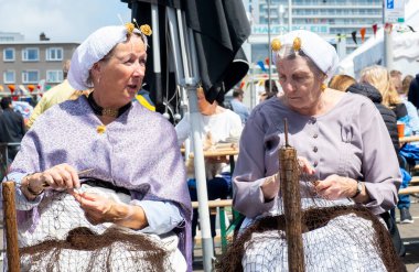 Scheveningen, Lahey, Hollanda - 22 Haziran 2024. New Ringa bayramı. Hollanda 'nın Scheveningen, Lahey ve Hollanda' da Ringa Bayramında Yaşlı Kadınlar Ağları örüyor.