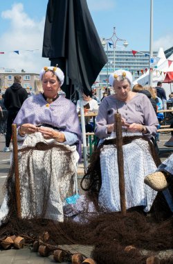 Scheveningen, Lahey, Hollanda - 22 Haziran 2024. New Ringa bayramı. Hollanda 'nın Scheveningen, Lahey ve Hollanda' da Ringa Bayramında Yaşlı Kadınlar Ağları örüyor.