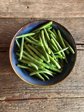Mavi Tabakta Yeşil Fasulye, ahşap masada üst manzara, sağlıklı yemek..