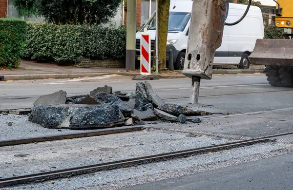 stock image Large piles of old asphalt on the road, preparation for repairs to the road with the tram line.