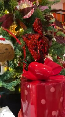 Hollanda, Bijenkorf 'taki bir alışveriş merkezinin Noel ağacında kırmızı noktalı yıldız ve diğer parlak ve pahalı Noel ağacı süslemeleri..