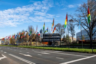 Alley or a street with many flags of different countries. Parade of flags near the World Forum in The Hague, Netherlands. clipart