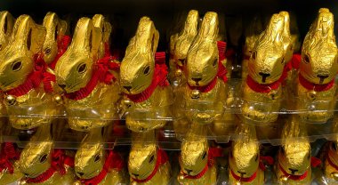 Altın folyoya sarılı Paskalya tavşanlarının arka planı Avrupa 'daki çocuklar için tipik bir tatlı satışıdır.