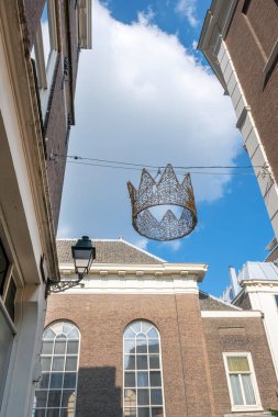 Kralın tacı mavi gökyüzünde arka planda ve eski Hollands binası olan eski şehir merkezinde.