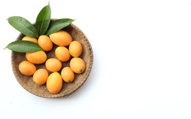 Beyaz zemin üzerinde izole edilmiş bambu bir sepetin içinde taze taze, olgun Marian eriği, Tayland meyvesi yığını yatıyordu (mayongchid maprang marian erik ve erik mango, thailand). Thailan 'ın sağlıklı meyveleri