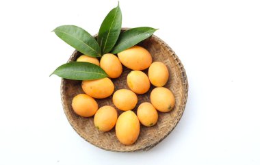 Beyaz zemin üzerinde izole edilmiş bambu bir sepetin içinde taze taze, olgun Marian eriği, Tayland meyvesi yığını yatıyordu (mayongchid maprang marian erik ve erik mango, thailand). Thailan 'ın sağlıklı meyveleri