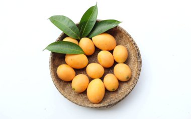 Beyaz zemin üzerinde izole edilmiş bambu bir sepetin içinde taze taze, olgun Marian eriği, Tayland meyvesi yığını yatıyordu (mayongchid maprang marian erik ve erik mango, thailand). Thailan 'ın sağlıklı meyveleri