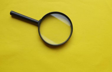 siyah çerçeve dikdörtgen şekilli beyaz ve sarı arkaplan üzerine bir büyüteç