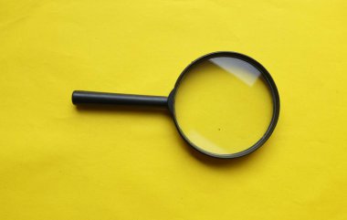 siyah çerçeve dikdörtgen şekilli beyaz ve sarı arkaplan üzerine bir büyüteç