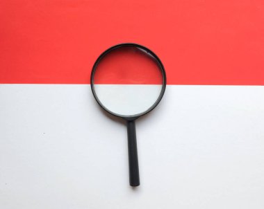 siyah çerçeve dikdörtgen şekilli beyaz ve kırmızı arkaplanda bir büyüteç