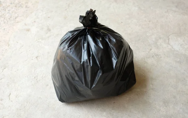 stock image black garbage bags isolated on the cement floor background.symbol of waste management and environmental