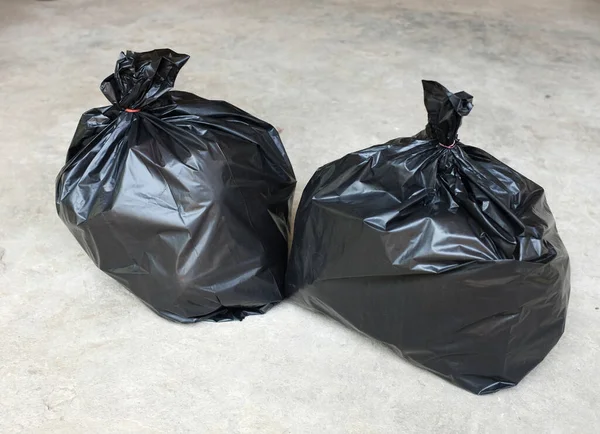 black garbage bags isolated on the cement floor background.symbol of waste management and environmental