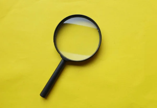 black frame a magnifying glass on Rectangle shape colored paper white and yellow background