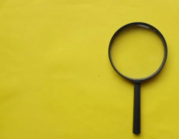black frame a magnifying glass on Rectangle shape colored paper white and yellow background