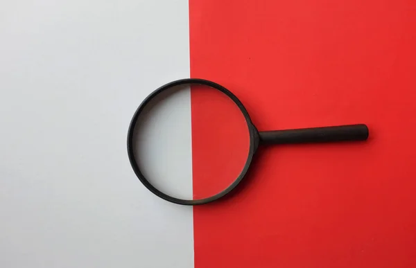 black frame a magnifying glass on Rectangle shape colored paper white and red background