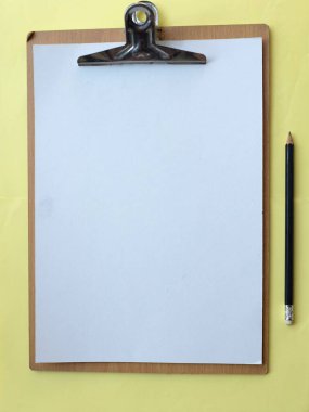 düz ve üst görünüm kağıt notlu bir pano, sarı pastel arka planda kalem, tasarım için boşluk kopyala. ofis kavramı.