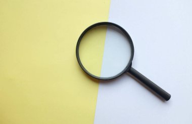 siyah çerçeve dikdörtgen şekilli bir büyüteç renkli kağıt beyaz ve sarı pastel arka plan