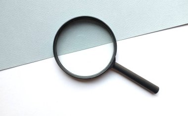 siyah çerçeve dikdörtgen şekilli bir büyüteç renkli kağıt beyaz ve gri pastel arka plan