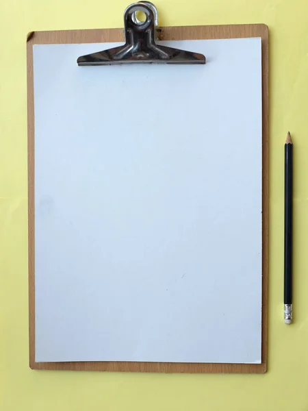ペーパーノート付きのクリップボード 黄色のパステルカラーの背景の鉛筆 デザインのためのコピースペースをフラットレイとトップビュー オフィスのコンセプト — ストック写真