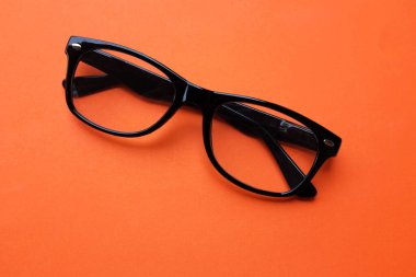 Modern bir gözlük, gözlük, gözlük, gözlük, gözlük, siyah çerçeveler. Turuncu bir arka planda parlak bir izolasyon sayesinde erkekler ve kadınlar için moda.