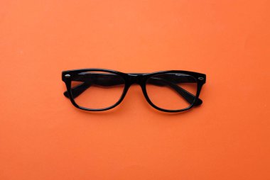 Modern bir gözlük, gözlük, gözlük, gözlük, gözlük, siyah çerçeveler. Turuncu bir arka planda parlak bir izolasyon sayesinde erkekler ve kadınlar için moda.