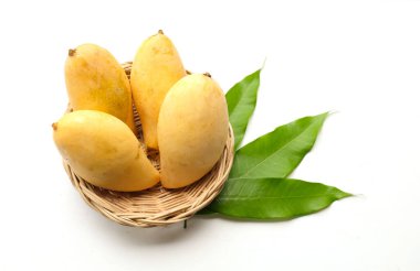 Üst ve düz bir bambu sepeti içinde olgun sarı mango, sarı mango, sarı mango, altın nam dok mai mango, barakuda mango (mangifera indica) kral beyaz arka planda izole edilmiş bambu sepetinde yatıyor.