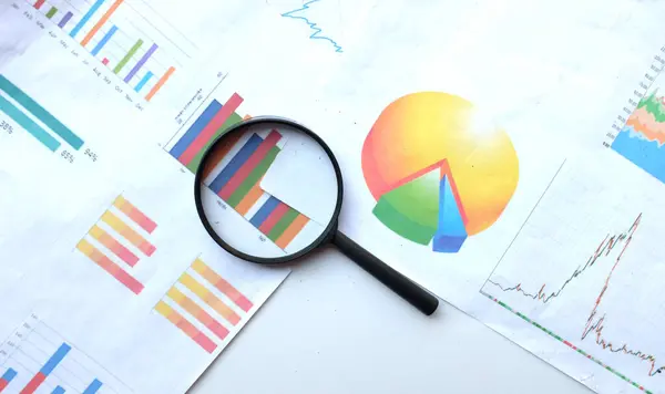 stock image top view and copy space a  magnifying glass and graph charts document isolate on a white  background