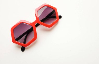 Kırmızı beşgen şeklindeki güneş gözlüklerini kapat. Beyaz arkaplanda izole et.