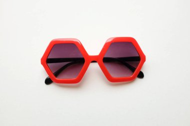 Kırmızı beşgen şeklindeki güneş gözlüklerini kapat. Beyaz arkaplanda izole et.